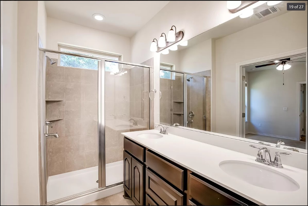 14215 McCoy Loop Austin, TX 78717 - Photo 16 of 27 Double vanity with white countertop, chrome fixtures, and dark wood cabinetry