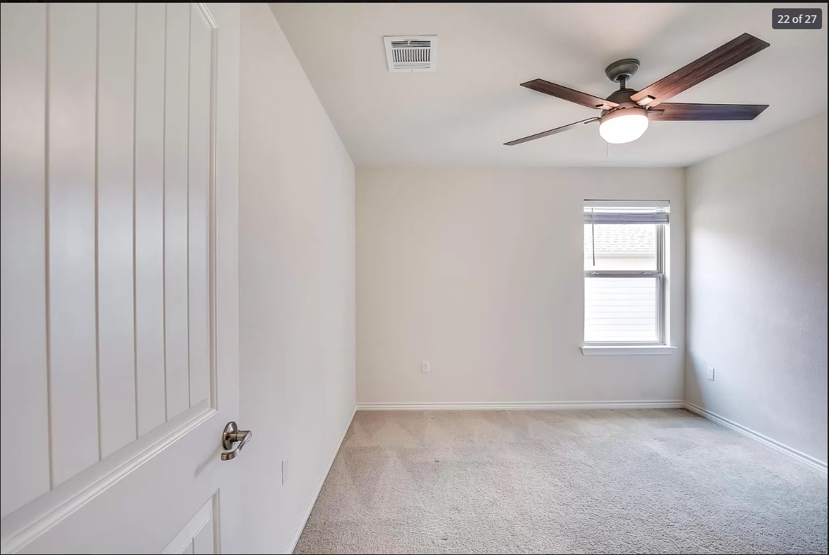 14215 McCoy Loop Austin, TX 78717 - Photo 19 of 27 Neutral wall colors, plush carpeting, a single window with blinds, and a ceiling fan with integrated lighting