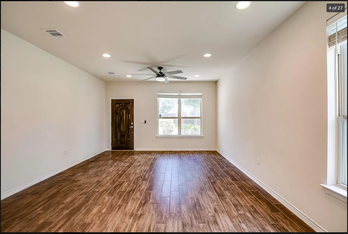14215 McCoy Loop Austin, TX 78717 - Photo 22 of 27 Spacious room featuring wood-finish flooring, recessed lighting, and a dark wood entry door with ornate detailing