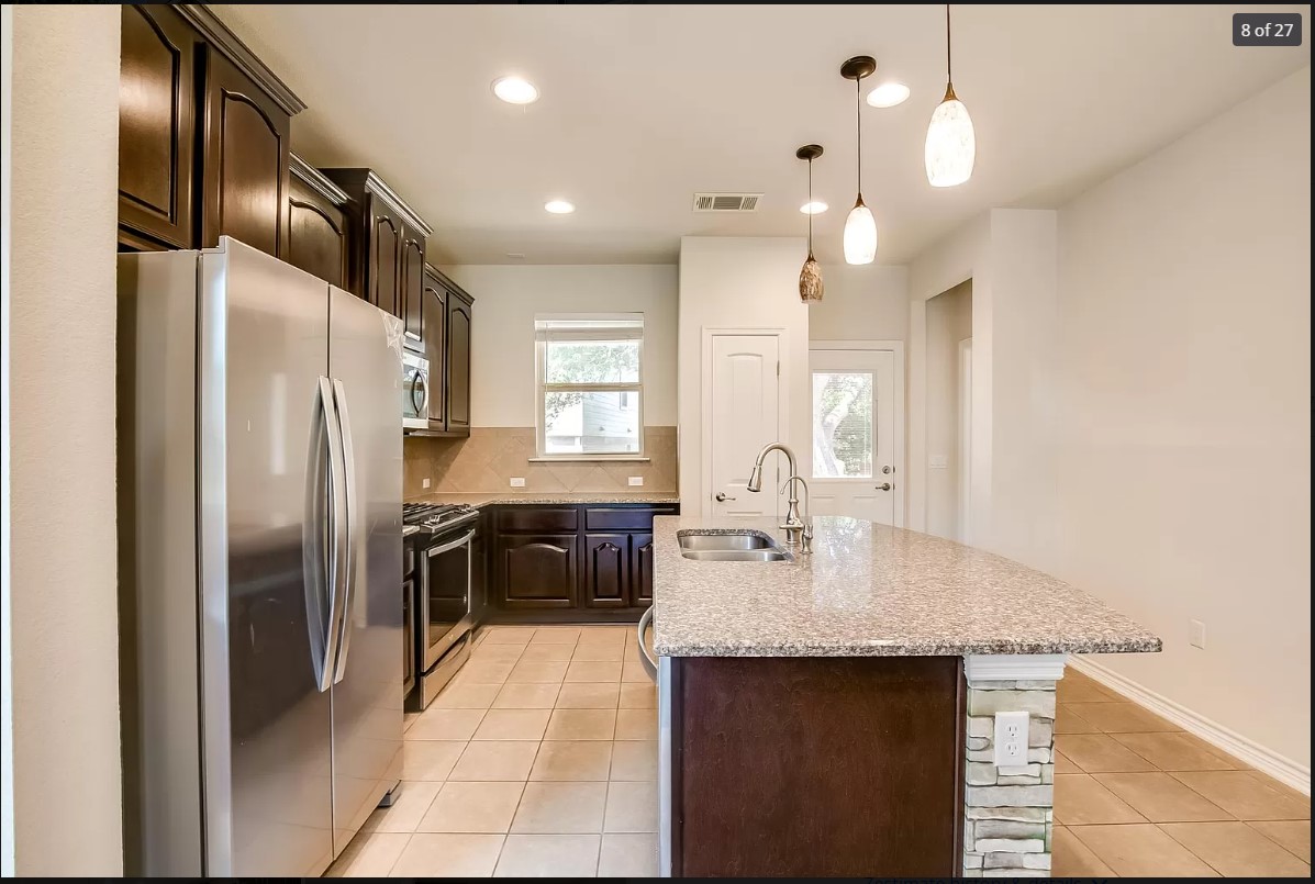 14215 McCoy Loop Austin, TX 78717 - Photo 5 of 27 Kitchen featuring a granite-topped island with a stone veneer base, stainless steel appliances, dark wood cabinetry, and recessed lighting