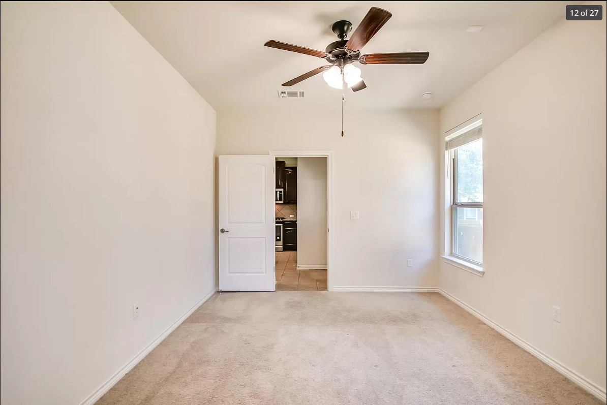 14215 McCoy Loop Austin, TX 78717 - Photo 9 of 27 Carpeted room featuring a ceiling fan with light fixture, a single window, and a white two-panel door