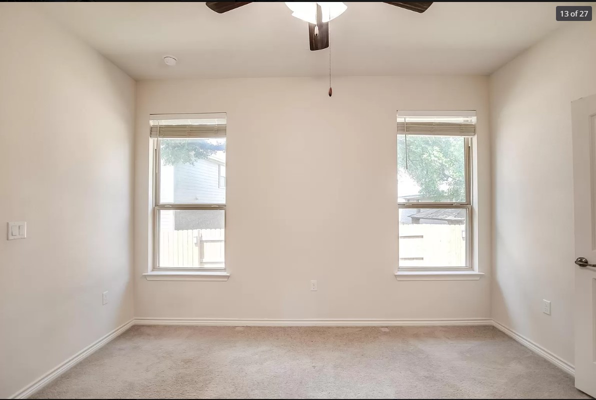 14215 McCoy Loop Austin, TX 78717 - Photo 10 of 27 Room featuring two windows with blinds, neutral carpeting, and a ceiling fan with integrated lighting