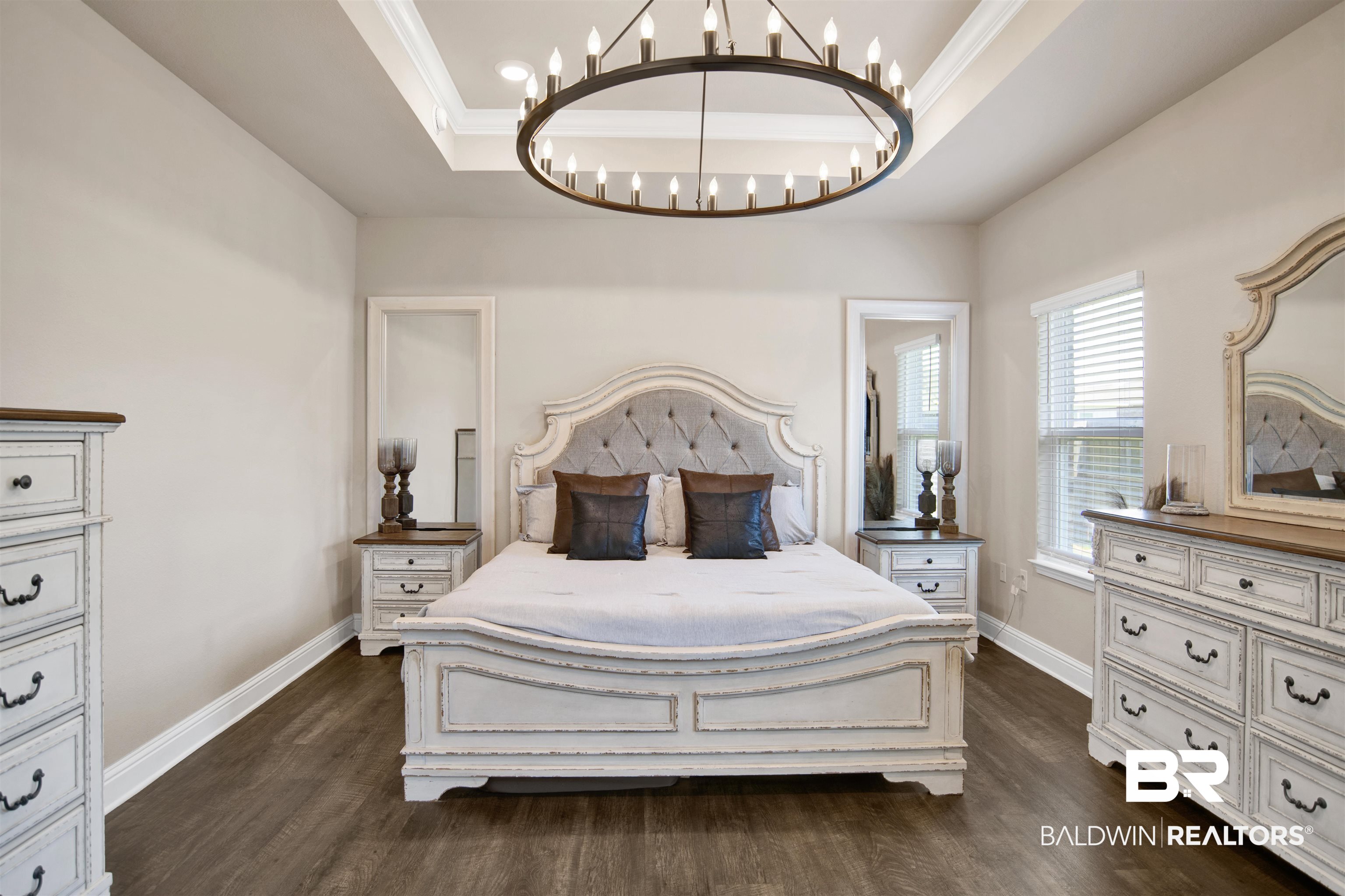 8493 Bronze Lane Foley, AL 36535 - Photo 18 of 38 Spacious room featuring wood-finish flooring, a tray ceiling with crown molding, and a large circular chandelier