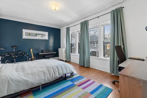 a bedroom with a bed and wooden floor