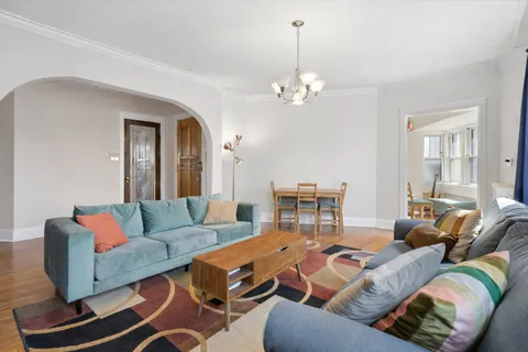 a living room with furniture a fireplace and a chandelier