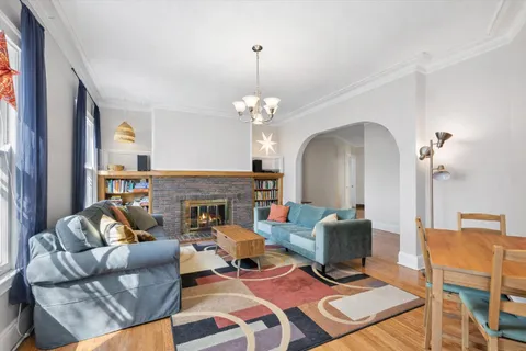 a living room with furniture a fireplace and a chandelier