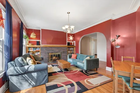 a living room with furniture a fireplace and a chandelier