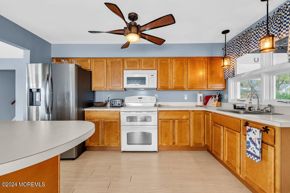 402 A Mantoloking Road Brick, NJ 08723 - Photo 12 of 51 a kitchen with stainless steel appliances granite countertop a sink a stove a refrigerator a washer dryer and white cabinets