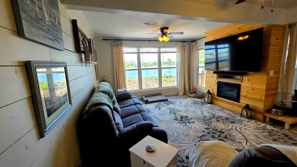 a living room with furniture a flat screen tv and a fireplace