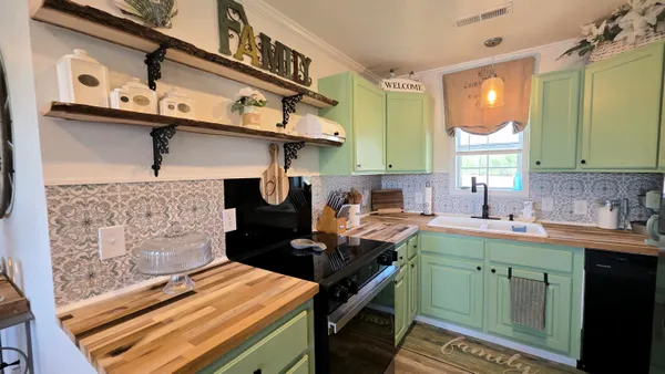 a kitchen with a sink cabinets and wooden floor