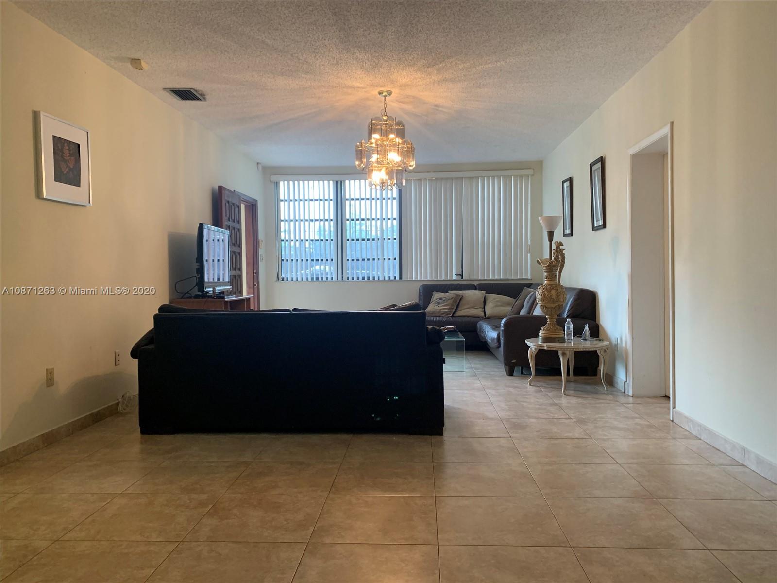 105 Southwest 22nd Road Miami, FL 33129 - Photo 11 of 26 a living room with furniture and a chandelier