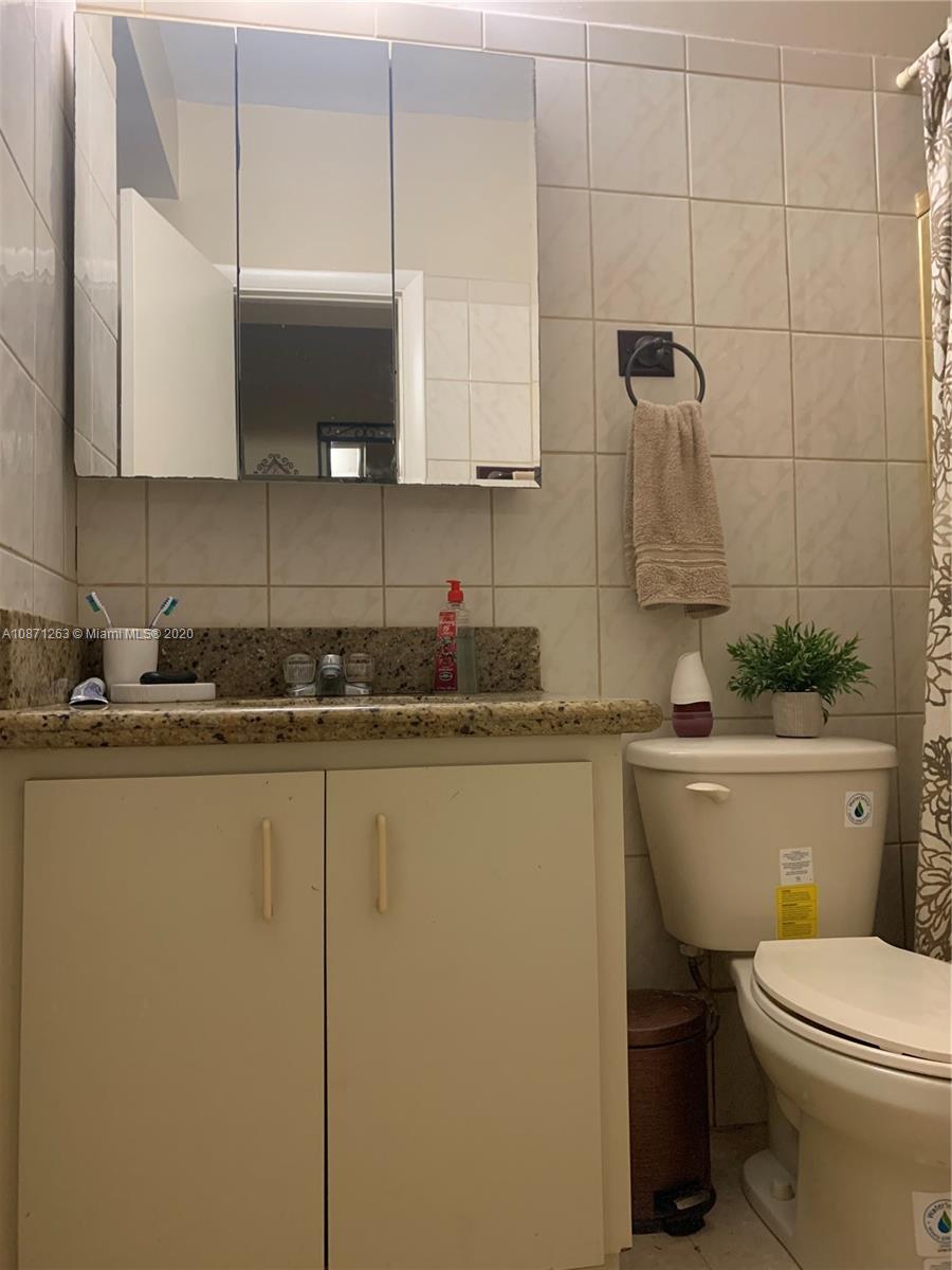 105 Southwest 22nd Road Miami, FL 33129 - Photo 21 of 26 a bathroom with a granite countertop toilet a sink and mirror