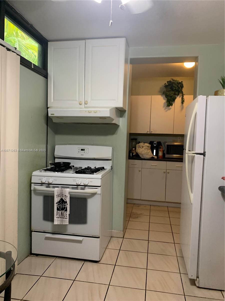 105 Southwest 22nd Road Miami, FL 33129 - Photo 23 of 26 a kitchen with a stove a refrigerator and a microwave