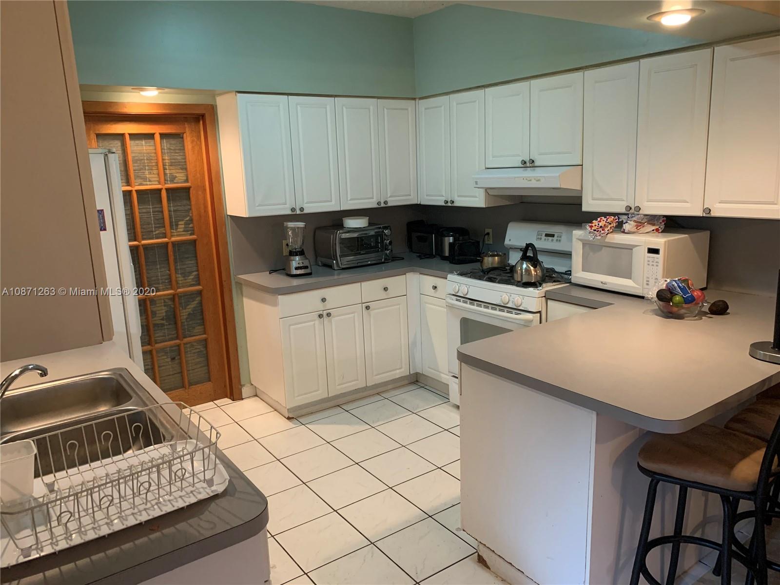 105 Southwest 22nd Road Miami, FL 33129 - Photo 8 of 26 a kitchen with a sink and cabinets