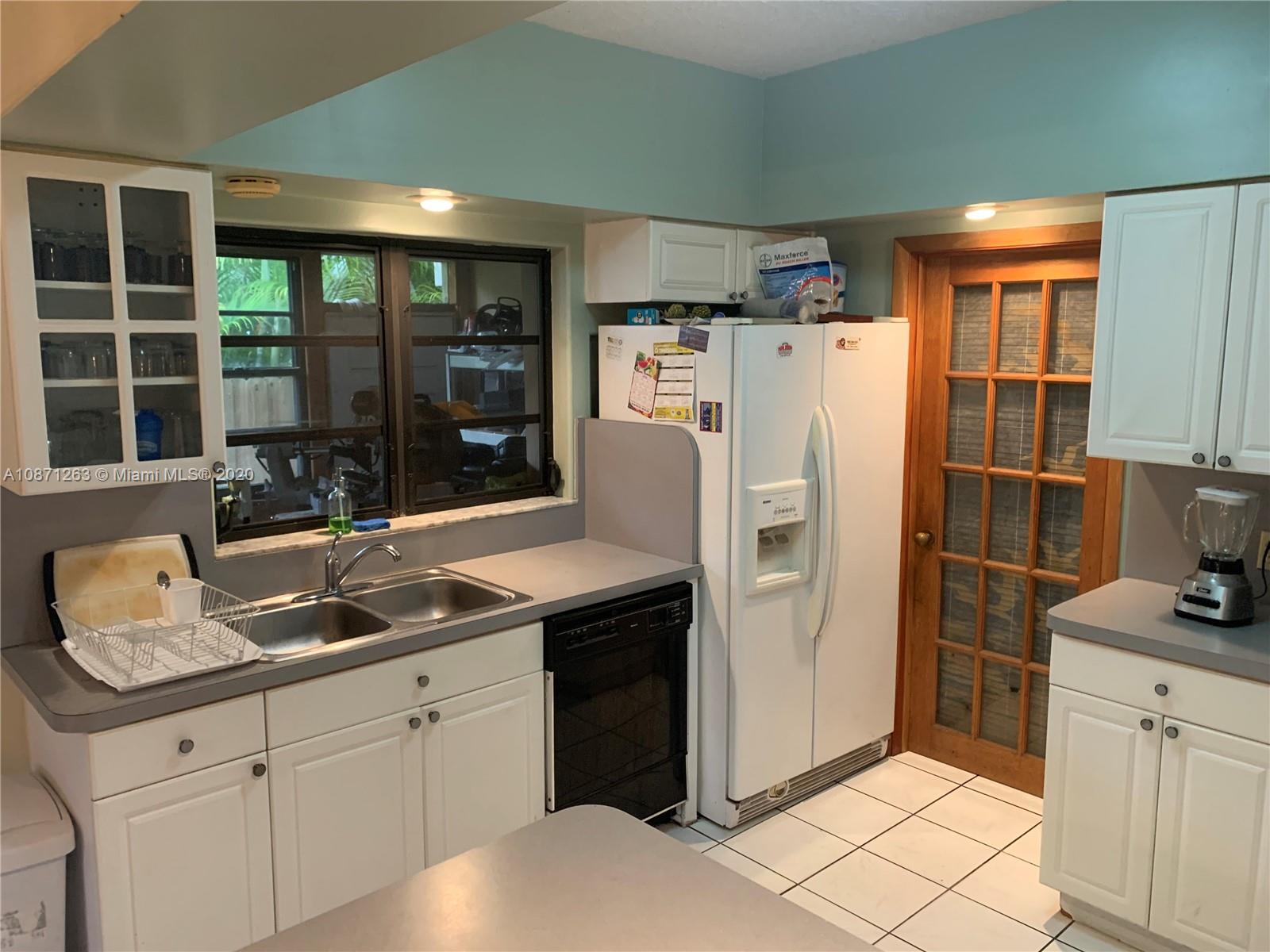 105 Southwest 22nd Road Miami, FL 33129 - Photo 9 of 26 a kitchen with refrigerator and window