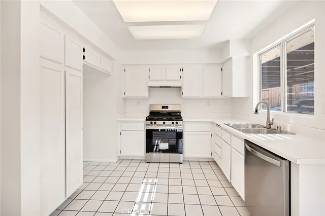 a kitchen with a stove top oven sink and cabinets