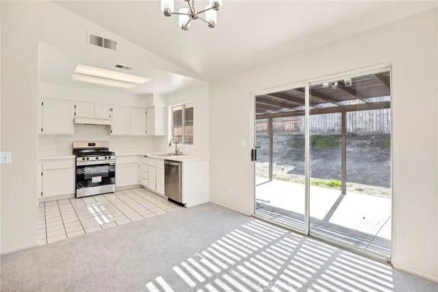 a kitchen with stainless steel appliances wooden floor and a refrigerator