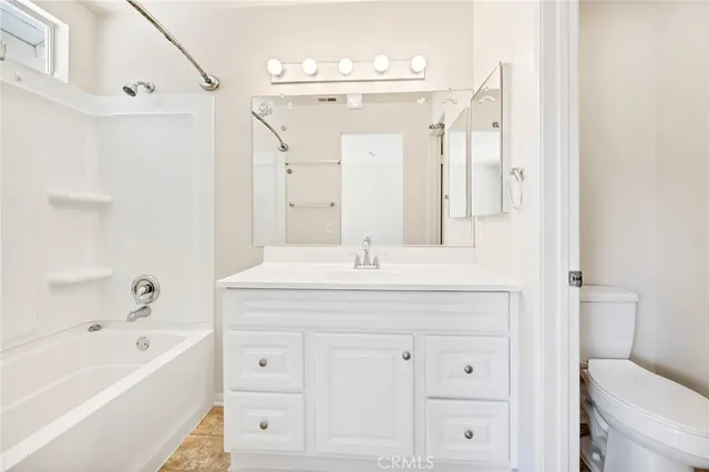 a bathroom with a granite countertop sink a toilet and bathtub