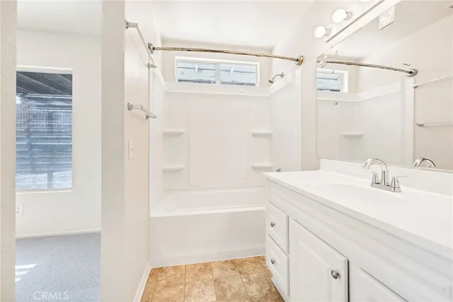 a bathroom with a bathtub shower sink vanity and a mirror