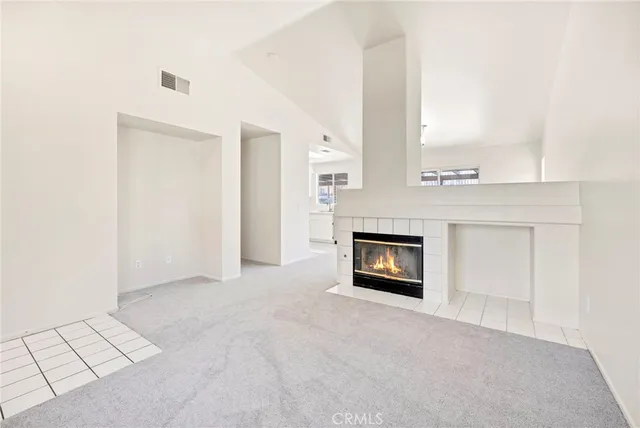 an empty room with windows and a fireplace