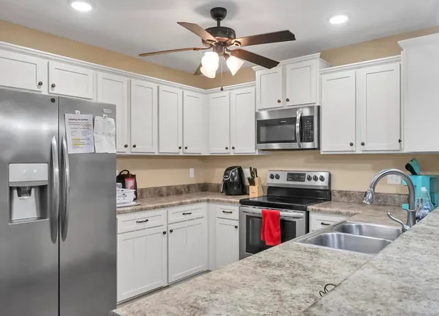 a kitchen with stainless steel appliances granite countertop a stove a sink and a microwave