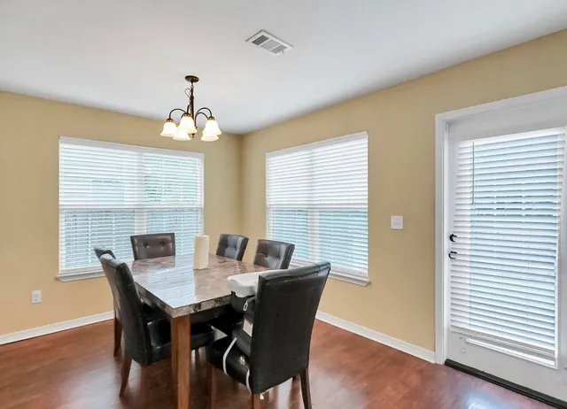 a view of a dining room with furniture wooden floor and a chandelier