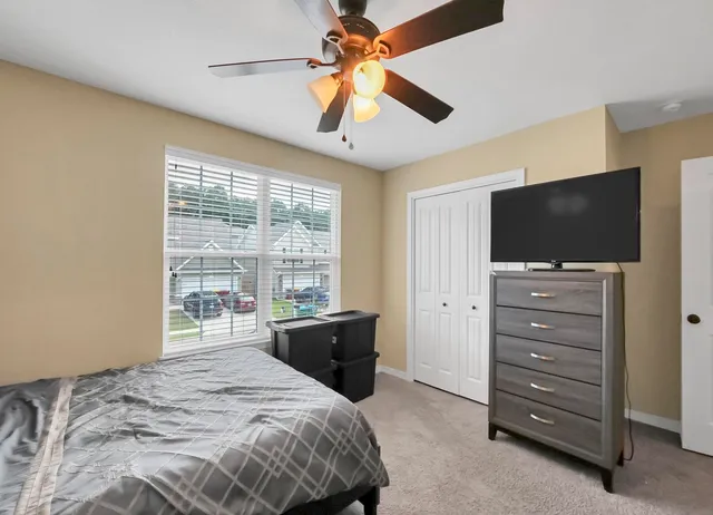 a bedroom with a bed and a large window