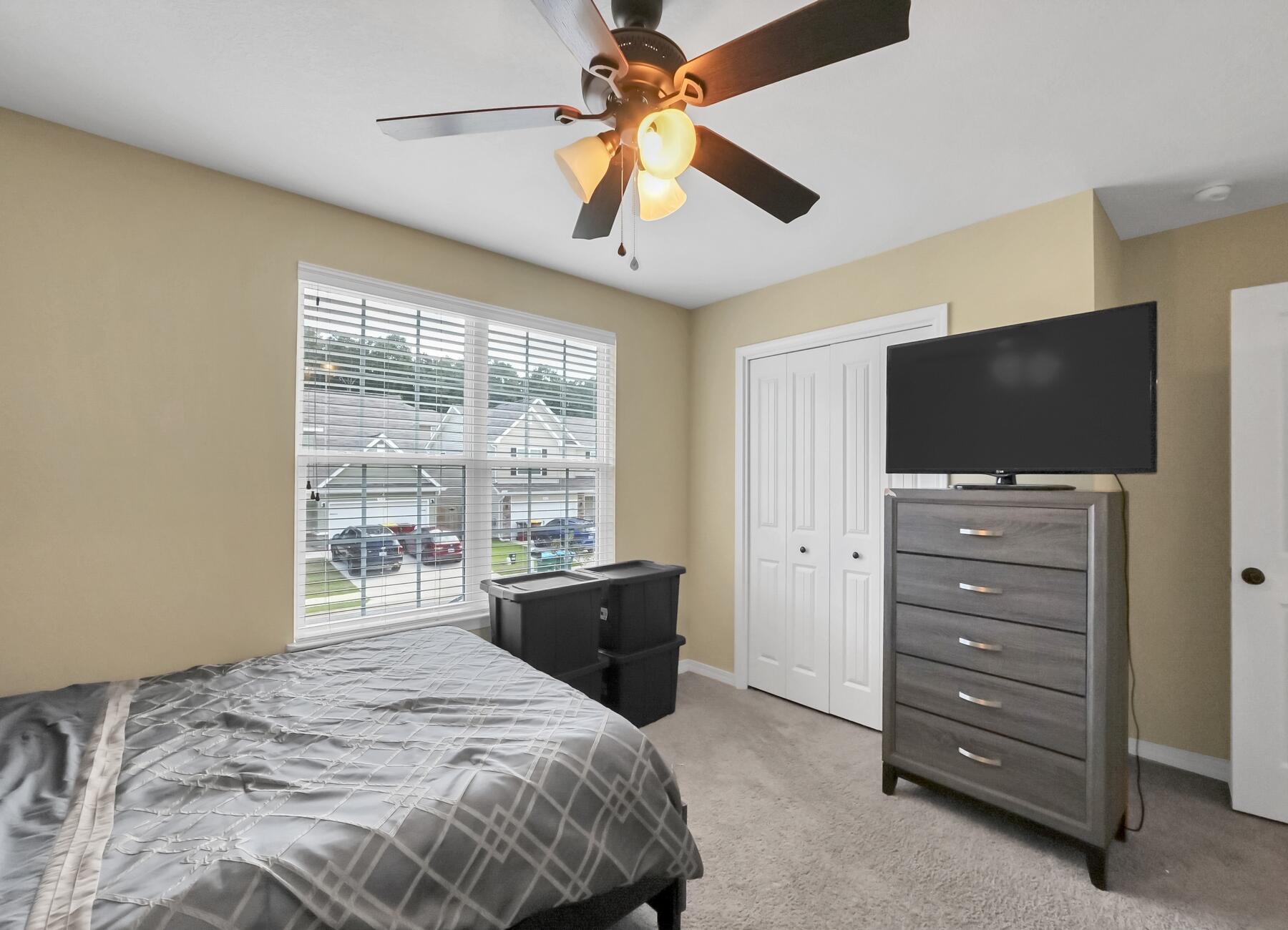 220 Wainwright Drive Crestview, FL 32539 - Photo 39 of 56 a bedroom with a bed and a flat tv screen on dresser