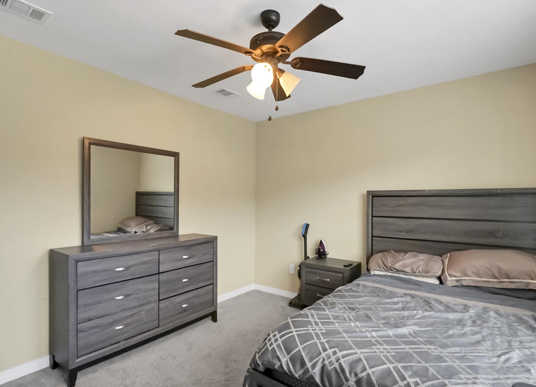 220 Wainwright Drive Crestview, FL 32539 - Photo 40 of 56 a bedroom with a bed and a chandelier