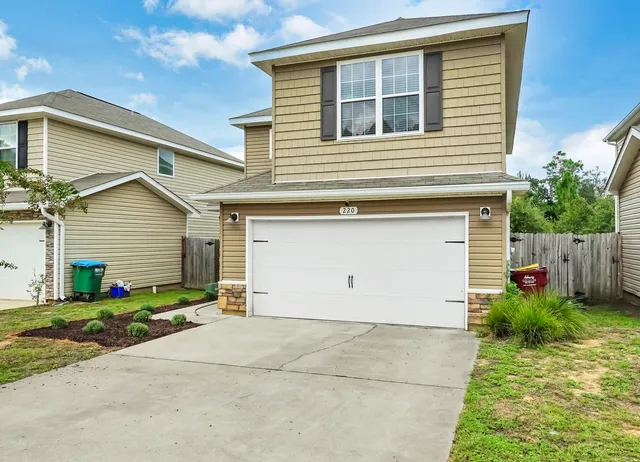 a view of a house with backyard and garden
