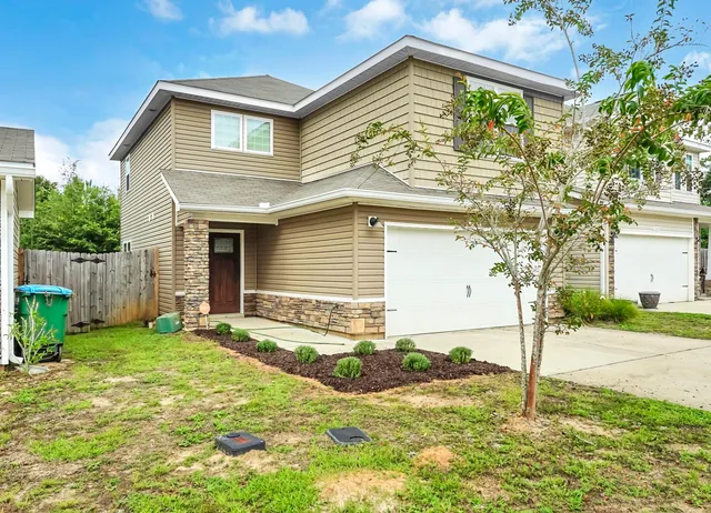 a house that has a tree in front of the house
