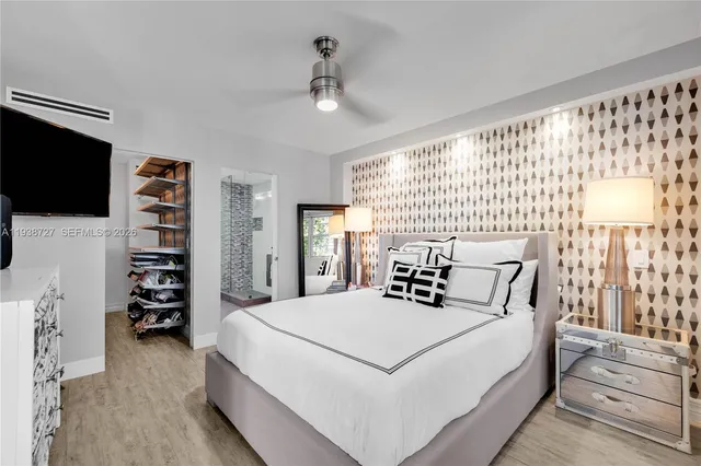 a bedroom with a large bed and a flat tv screen