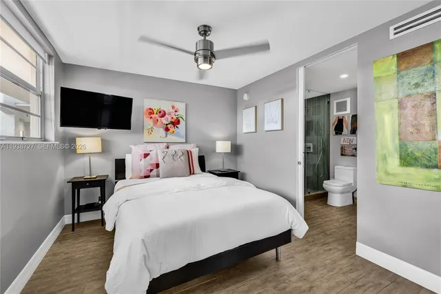 a bedroom with a large bed a flat screen tv and a window