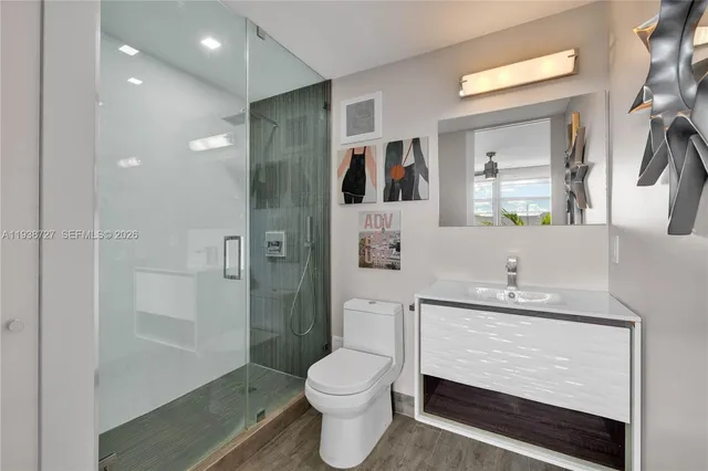 a bathroom with a sink a toilet and shower