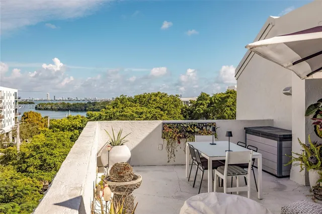 a roof deck with table and chairs a barbeque with potted plants
