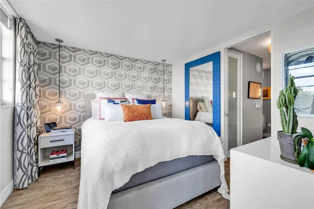 a bedroom with a bed and a large mirror on the dresser