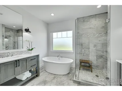 a bathroom with a tub sink and mirror