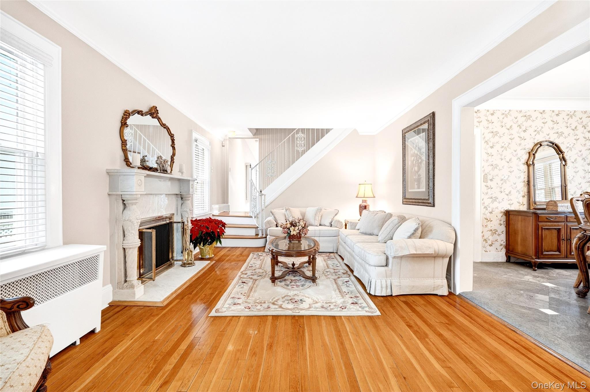 3334 Country Club Road Bronx, NY 10465 - Photo 6 of 49 Living area with radiator heating unit, crown molding, wallpapered walls, a glass covered fireplace, and hardwood / wood-style floors