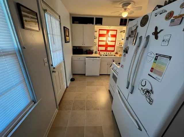a kitchen with stainless steel appliances a refrigerator a sink a stove top oven a washer and dryer