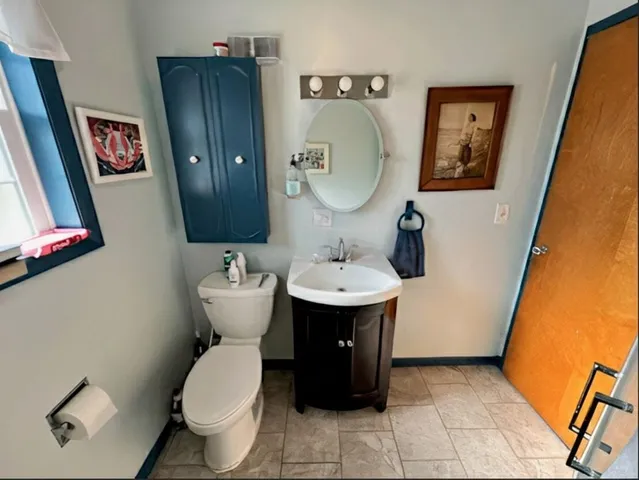 a bathroom with a toilet sink and mirror