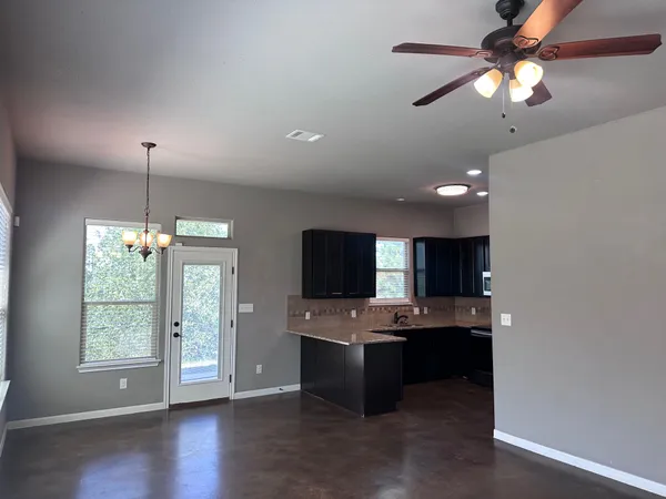 a kitchen with a sink chandelier and living room view