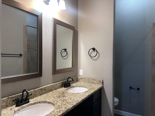 a bathroom with a granite countertop sink and a mirror