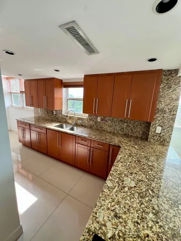 a kitchen with stainless steel appliances granite countertop a sink stove and cabinets