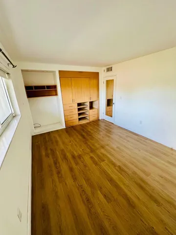 a view of a room with wooden floor and a window