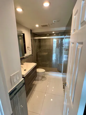 a bathroom with a granite countertop sink toilet and shower