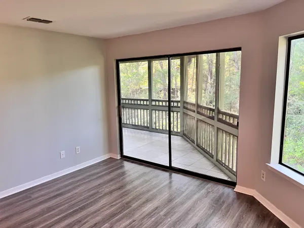 a view of a room with wooden floor and windows