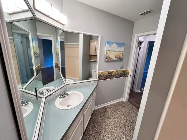 a bathroom with a sink a toilet a mirror and shower