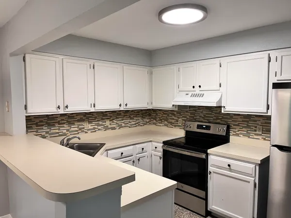 a kitchen with a stove and white cabinets