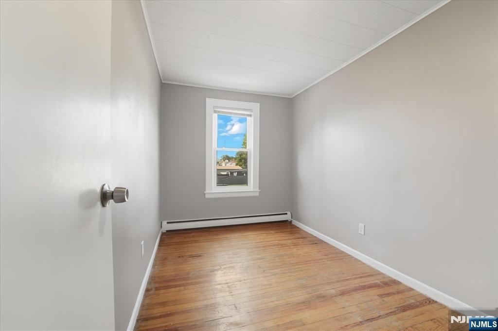 102 Exton Avenue North Arlington, NJ 07031 - Photo 11 of 18 an empty room with wooden floor and windows