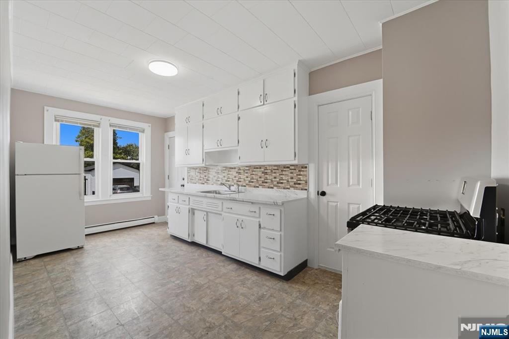 102 Exton Avenue North Arlington, NJ 07031 - Photo 17 of 18 a kitchen with white cabinets and white appliances